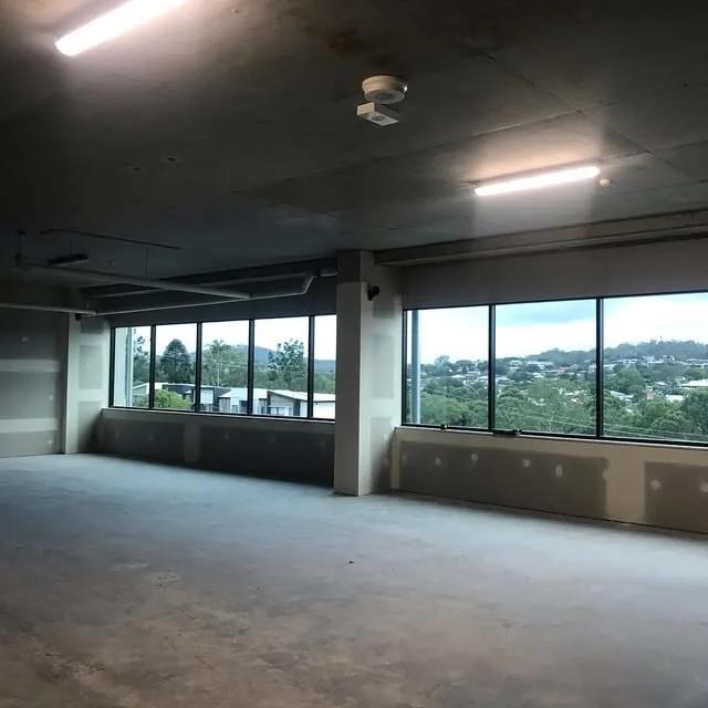 An empty commercial fit-out floor with city views, before the plumbing goes in